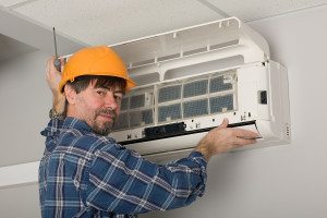 Picture of man installing Air Conditioner