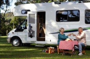 Picture of older couple sitting at a table next to their motor home